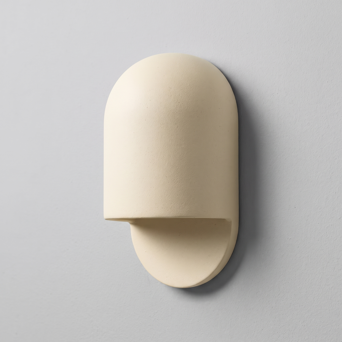 AX472 white ceramic wall sconce, three-quarter view on a light grey wall