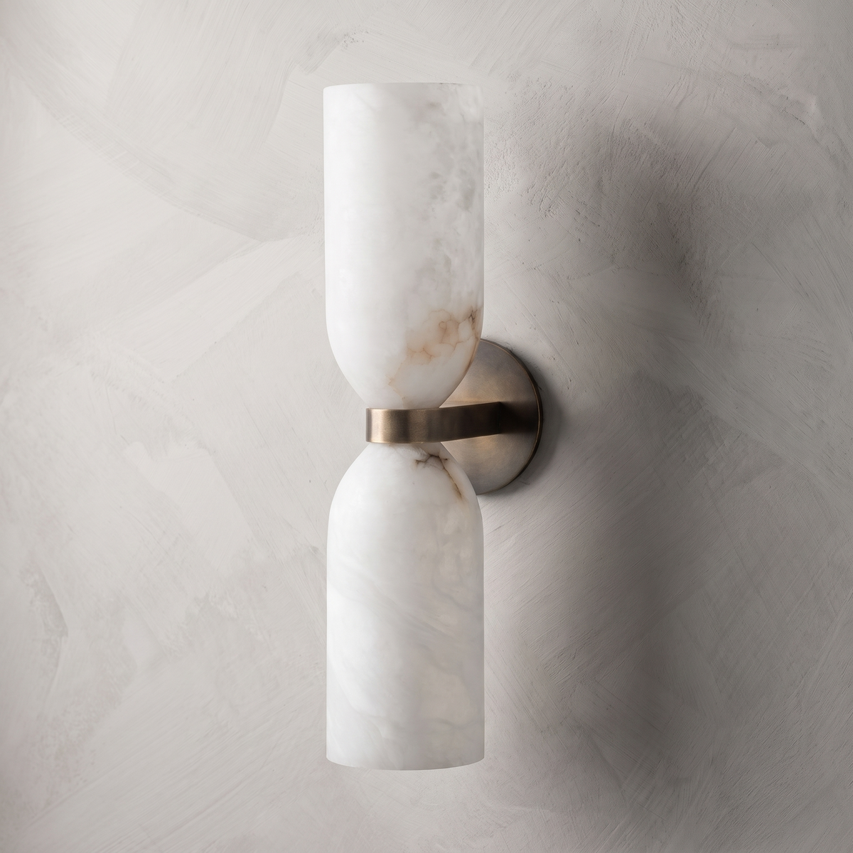 Natural stone veining on alabaster wall sconce with bronze backplate