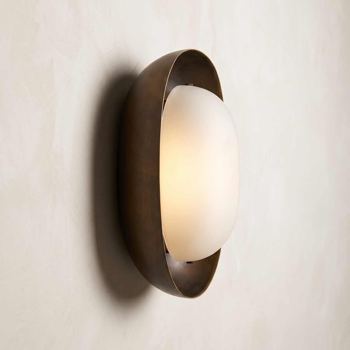 Modern bronze wall sconce side view – AX924 sculptural wall light with opal glass shade and patinated brass shell